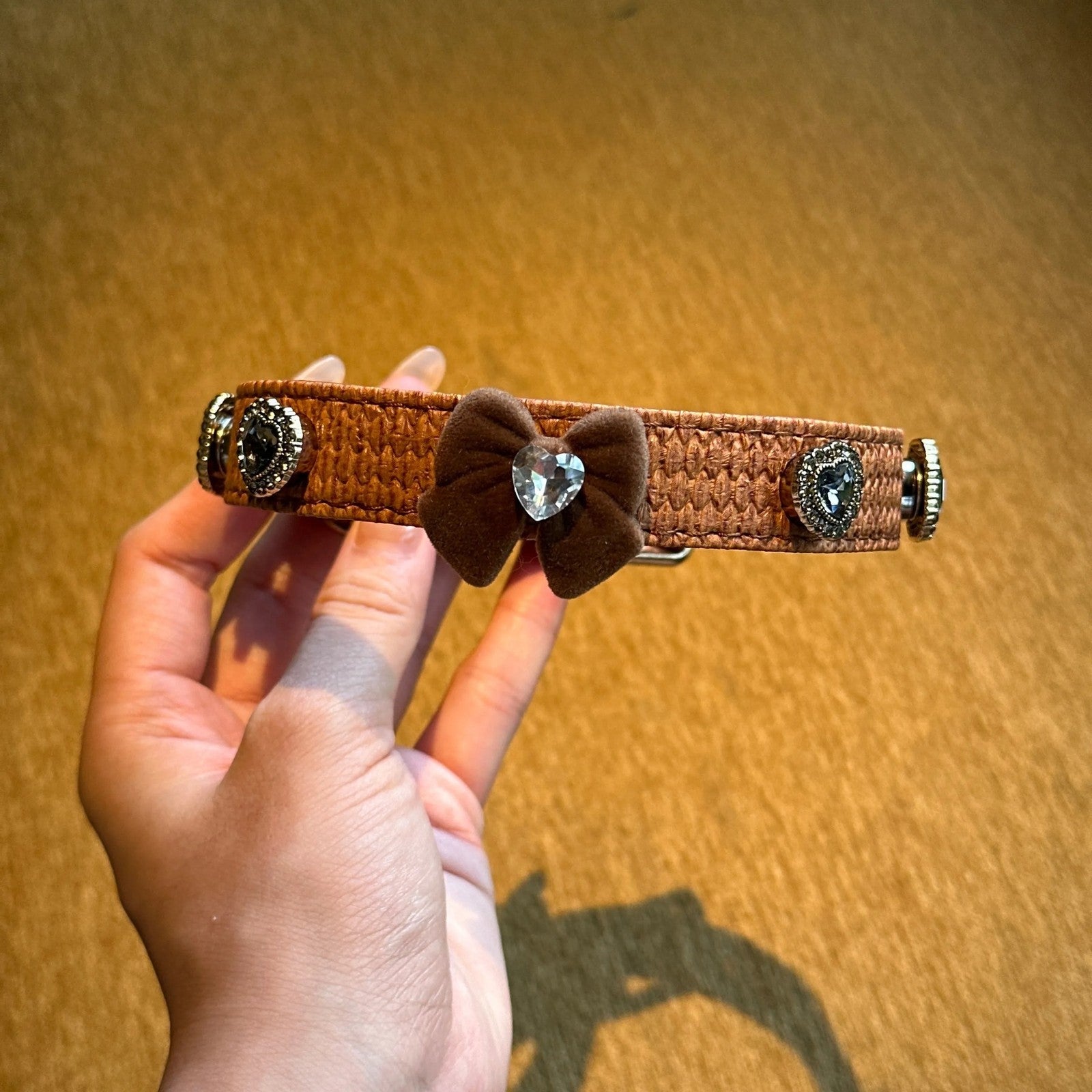 Vintage caramel brown butterfly dog collar held in hand